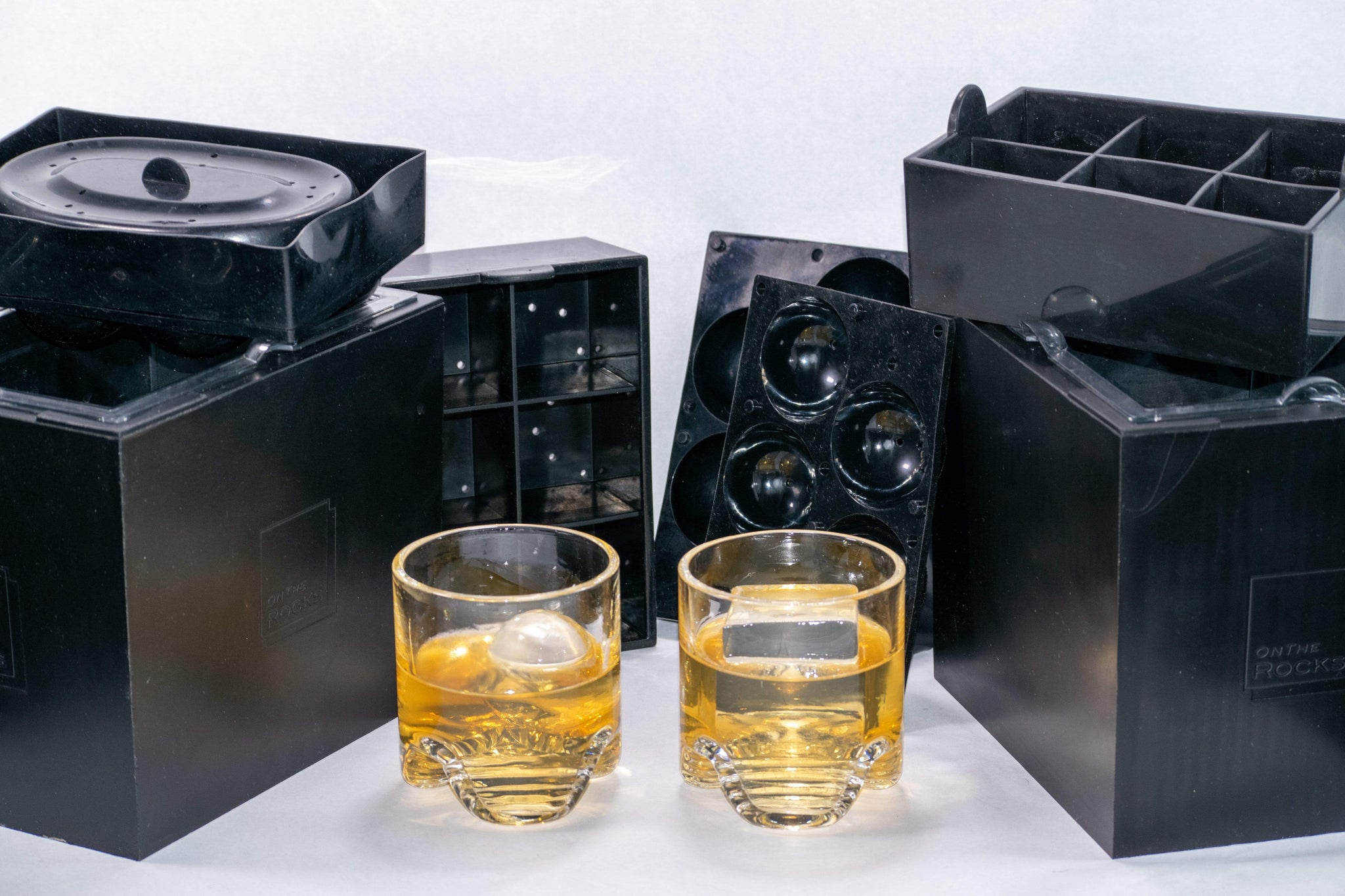 Two OnTheRocks IceBox clear ice makers including trays to make ice spheres and large ice cubes plus 2 hand-blown rocks glass tumblers