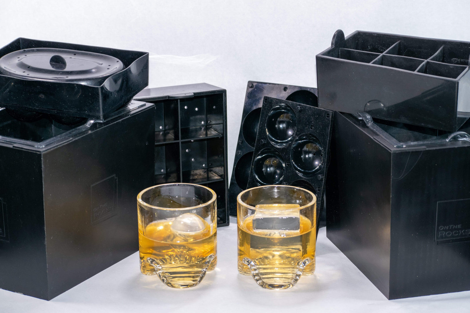 Two OnTheRocks IceBox clear ice makers including trays to make ice spheres and large ice cubes plus 2 hand-blown rocks glass tumblers